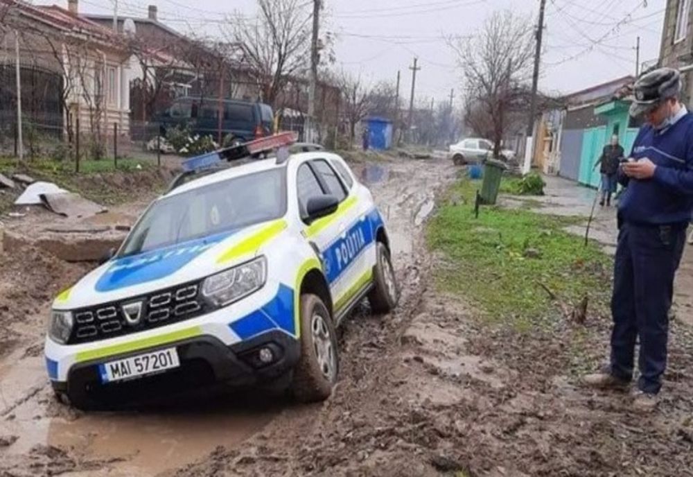 Mașină a poliției rămasă împotmolită în noroi pe o stradă din Brăila